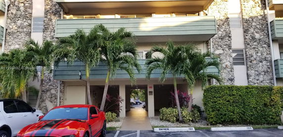 Front view of a residential building with stone facade and balconies.