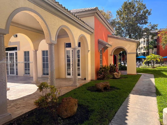 Front view of a building with arched openings and glass doors.