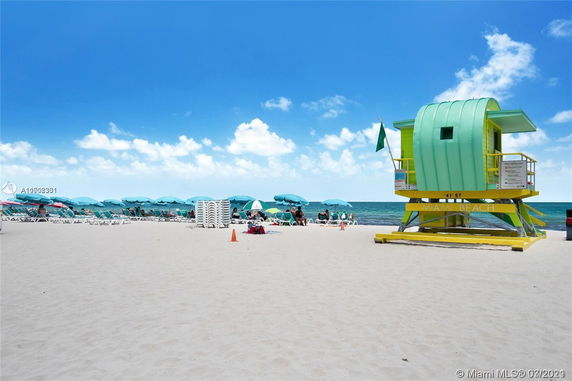 Beach scene with lifeguard tower and sun loungers.