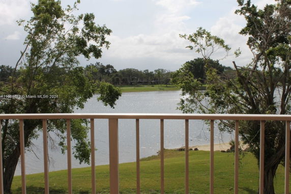 View from a balcony overlooking a lake and trees.