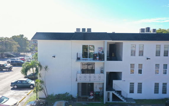 Front view of a multi-story building with external staircases and balconies.