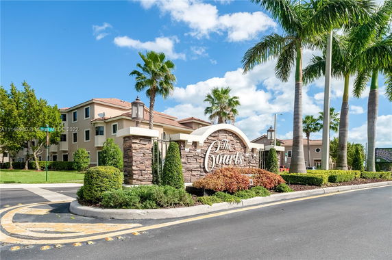 Front view of a multi-story residential building with a sign reading 'The Courts' in front.