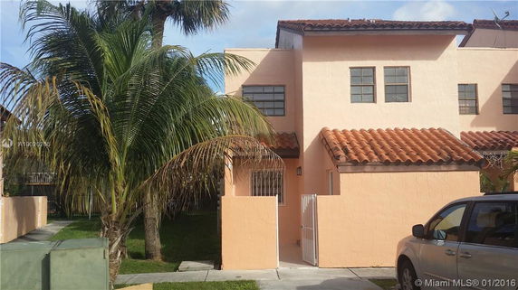 Front view of a two-story house with a tiled roof and a small gate entrance.