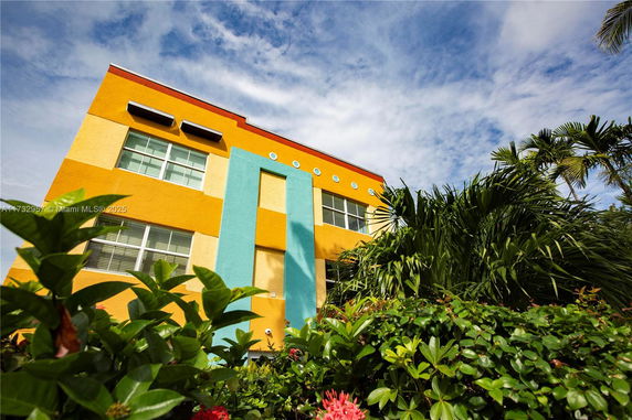 Front view of a colorful multi-story building with bright yellow and blue accents.