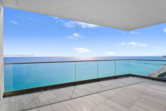 Panoramic view from a balcony overlooking the ocean and beach.