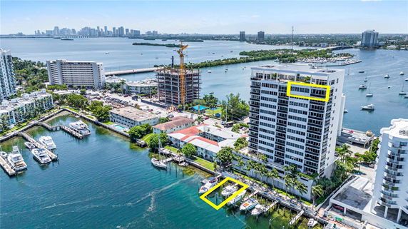 Panoramic view of waterfront buildings and marina with boats.