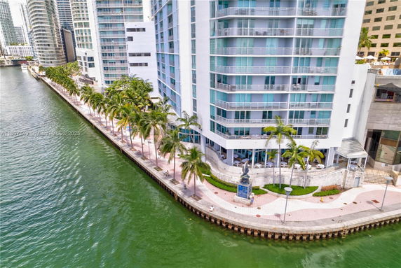 Front view of a high-rise building next to a waterway.