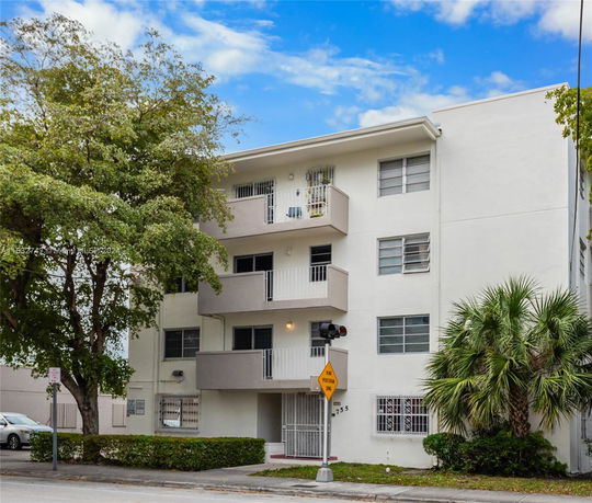 Front view of a four-story residential building with balconies.