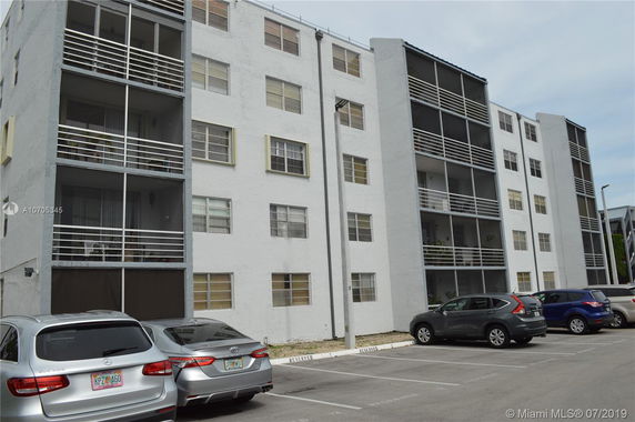 Front view of a multi-story apartment building with balconies.