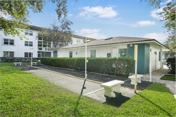 Front view of a single-story building with a shuffleboard court.