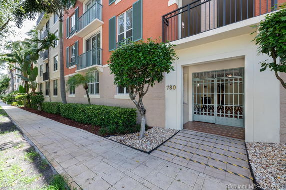 Front view of a multi-story residential building with balconies and a main entrance.