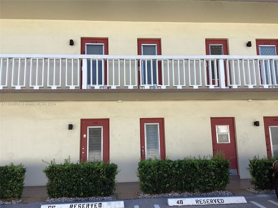 Front view of a two-story building with balconies and door entrances.