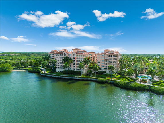 View of a multi-story waterfront residential building with balconies.