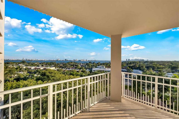 Panoramic view from a balcony overlooking a cityscape and body of water.