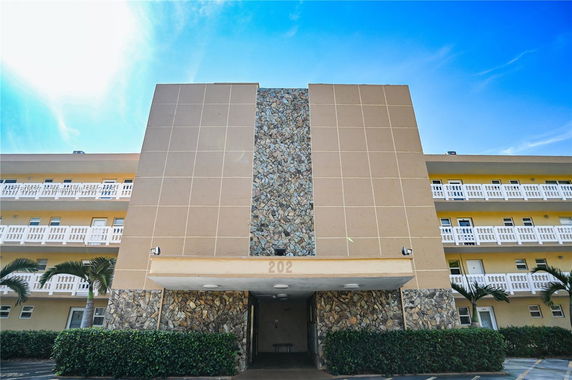 Front view of a multi-story building with stone and panel facade.