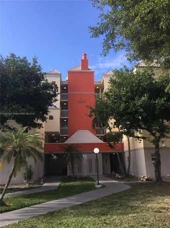 Front view of a multi-story building with a red central section and beige walls.