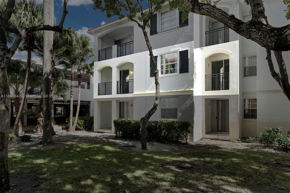 Front view of a three-story building with balconies and windows on each level.