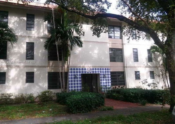 Front view of a multi-story building with an entrance featuring a blue and white checkered design.