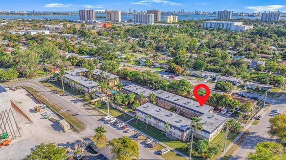 Aerial view showing multiple buildings and a surrounding neighborhood with greenery and streets.