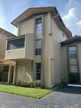 Front view of a multi-story house with a balcony and tiled roof.