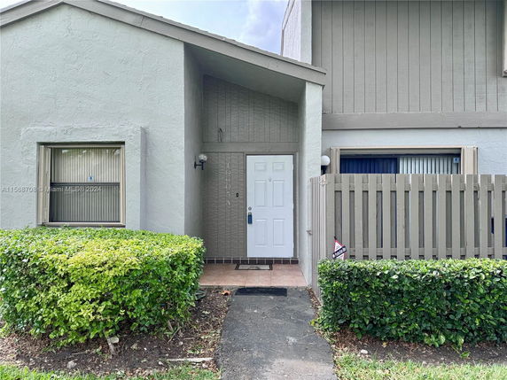Front view of a townhouse with a white exterior and a small porch.