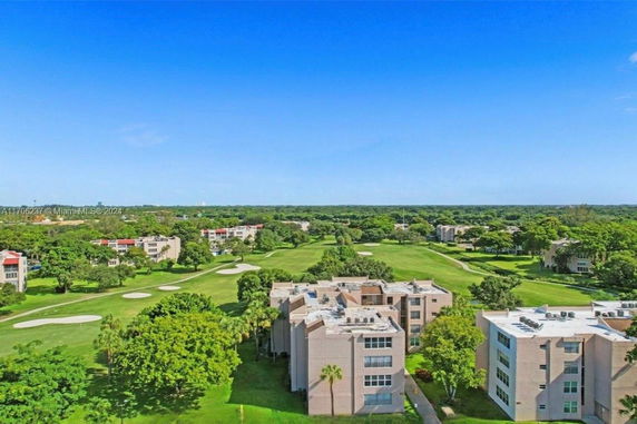 Panoramic view of buildings surrounded by a lush green landscape and golf course.