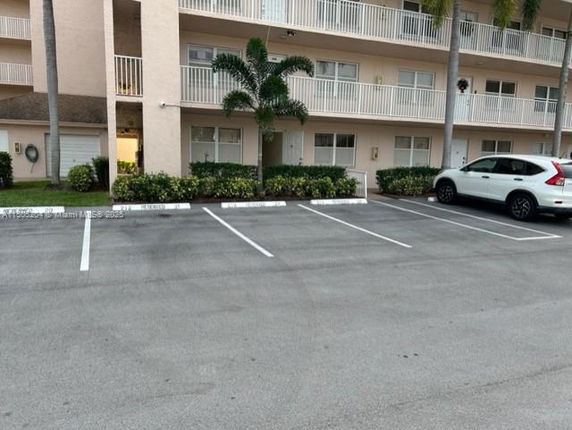 Outdoor parking area in front of a multi-story building.