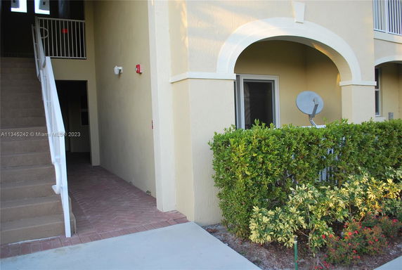 Front view of a building entrance with stairs and an archway.
