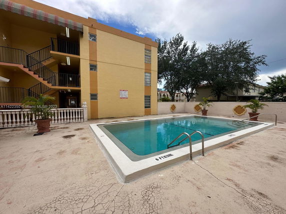 Outdoor swimming pool adjacent to a multi-story building.