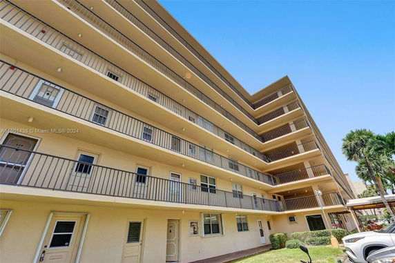 Front view of a multi-story apartment building with balconies.