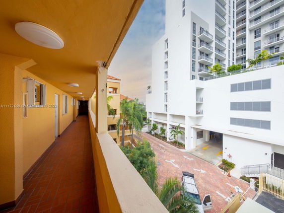 View of a residential building from a hallway, showing multiple floors and balconies.