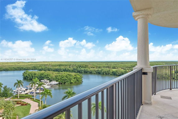 Panoramic view from a balcony overlooking a body of water and lush greenery.