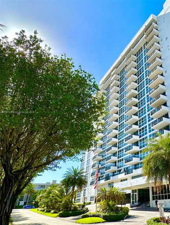Front view of a modern high-rise apartment building with multiple balconies.