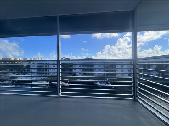 Panoramic view from a balcony showing residential buildings and a canal with boats.