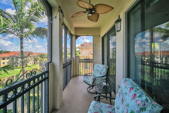 Balcony view overlooking residential area and lush landscaping.