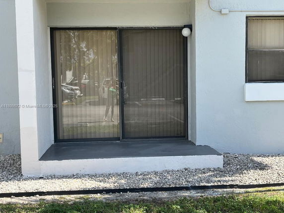 Front view of a building with sliding glass doors and a small step.