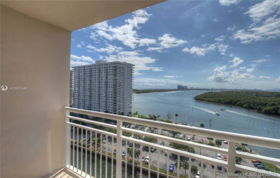 View from a balcony overlooking a body of water and a high-rise building.