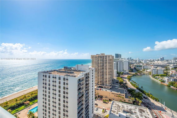 Elevated view of high-rise buildings near a beach and waterway.