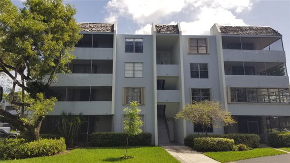 Front view of a multi-story apartment building with balconies.