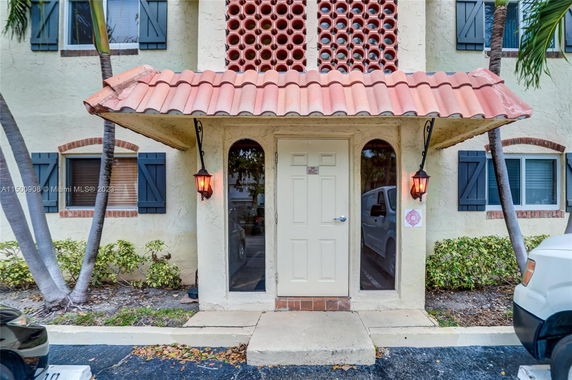 Front view of a building with an arched entryway and decorative tile roof.