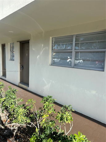 Front view of a building entrance with windows and doorway.