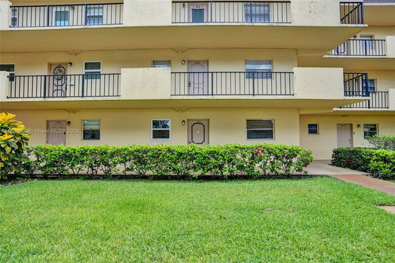 Front view of a multi-story apartment building with balconies.