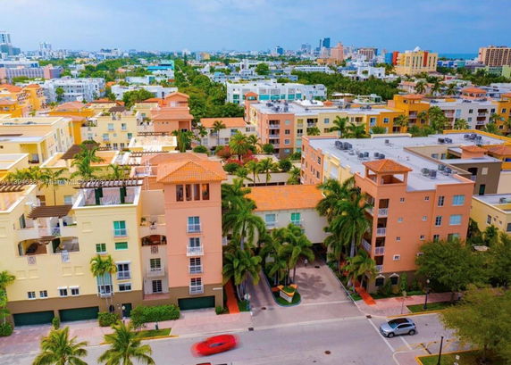 Aerial view of a residential area with multi-story apartment buildings and palm trees.