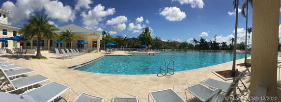 Outdoor swimming pool area with lounge chairs and umbrellas.