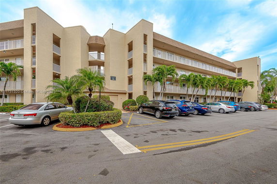 Facade of a multi-story building with an adjacent parking area.