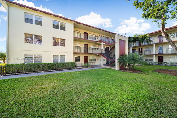 Front view of a three-story apartment building with external staircases.