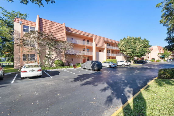 Outdoor parking area in front of a multi-story residential building.
