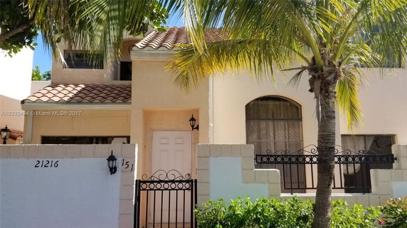 Front view of a house with a tiled roof and gated entrance.