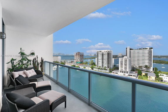 Panoramic view from a balcony overlooking a waterway and cityscape.