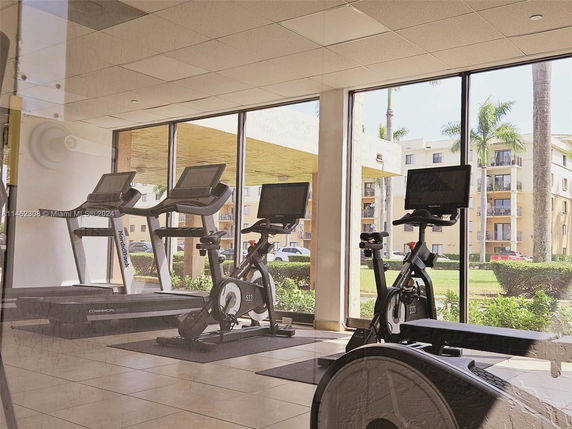 Indoor gym area with exercise equipment and large windows.